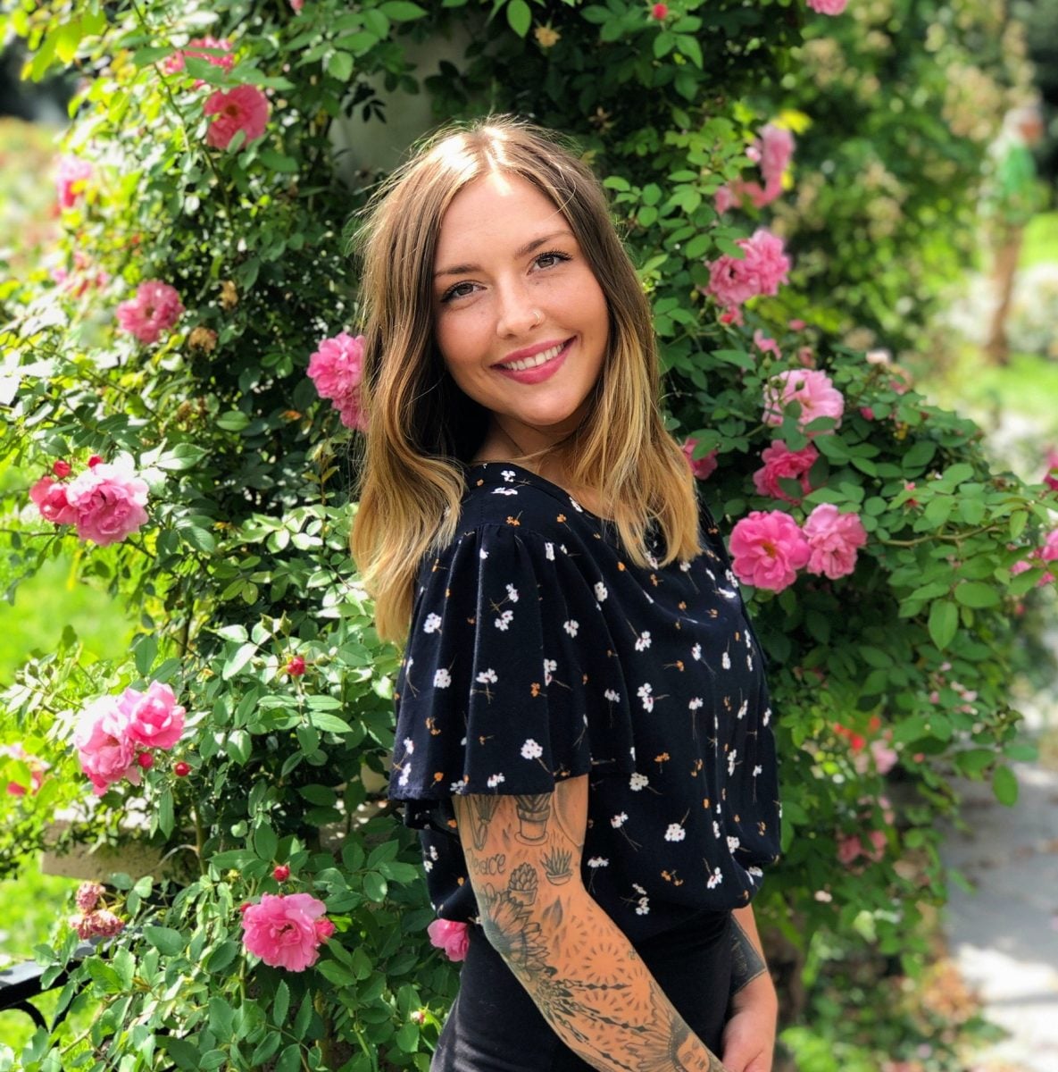 Vibrant portrait of Melanie in front of blooming pink primrose