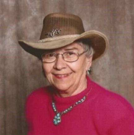Sharon in wide-brimmed hat and turqoiuse jewelry smiling