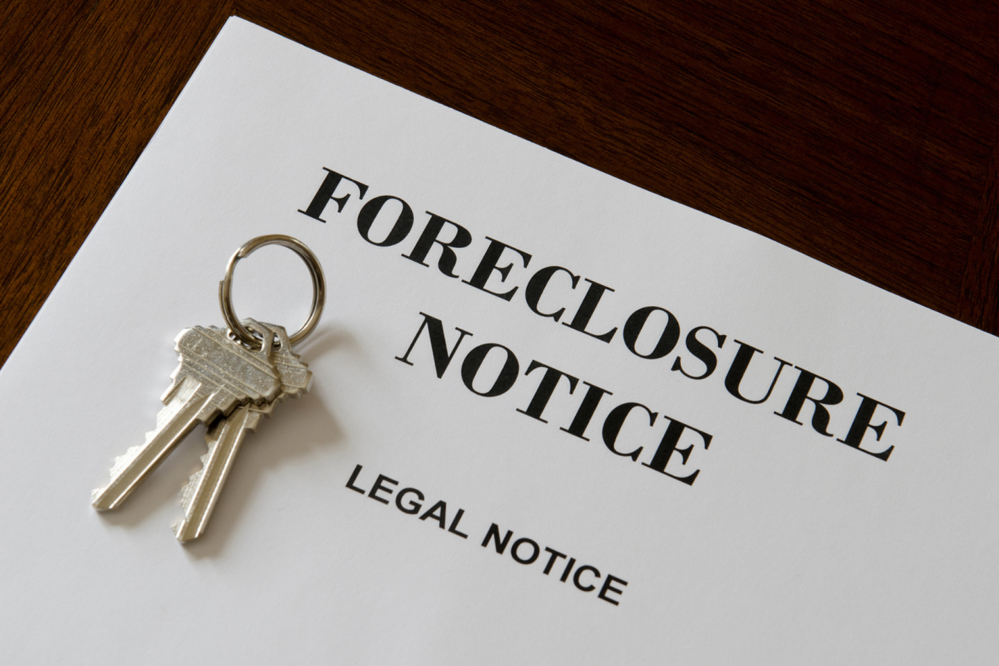 Two house keys sit on paper labeled "Foreclosure Notice"