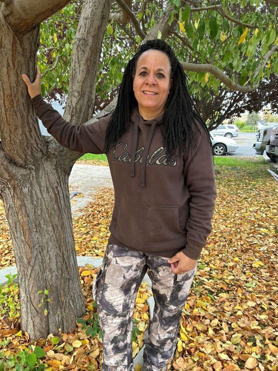 Joy standing by a tree