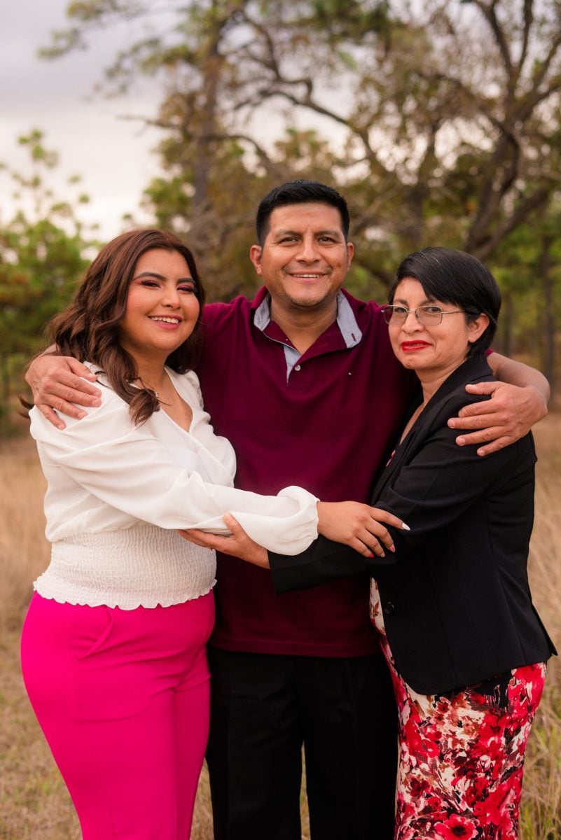 Three people hugging each other in beautiful natural light