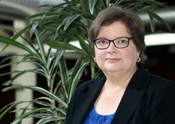 Headshot of Mary Griffin with plant in airy atrium